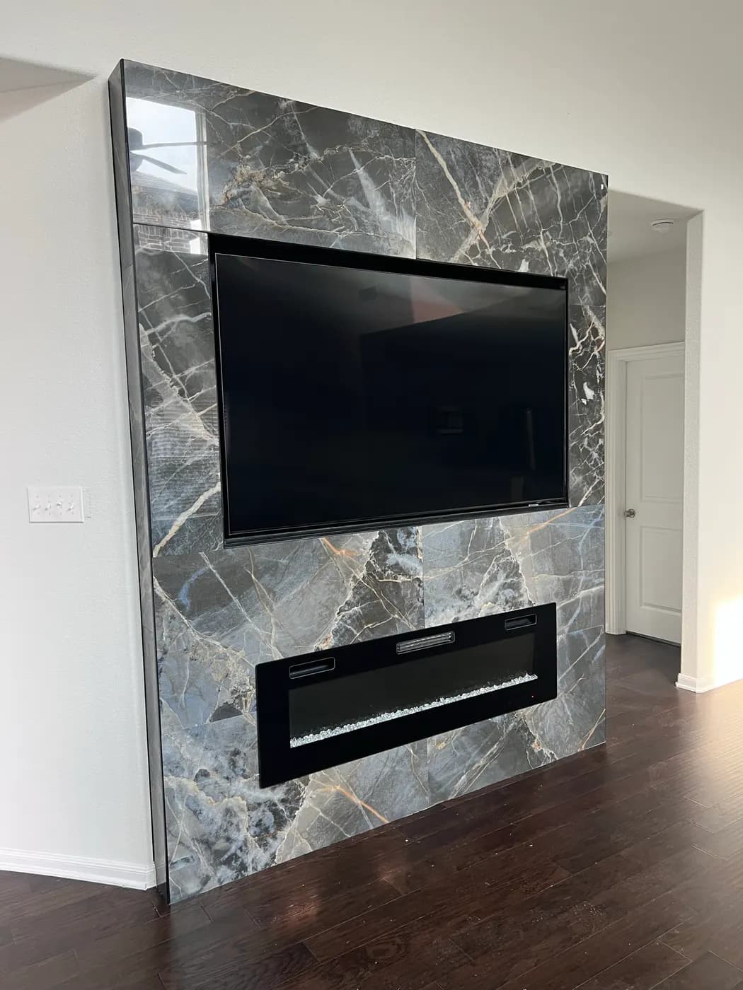 Gray stone-look media wall with a linear fireplace