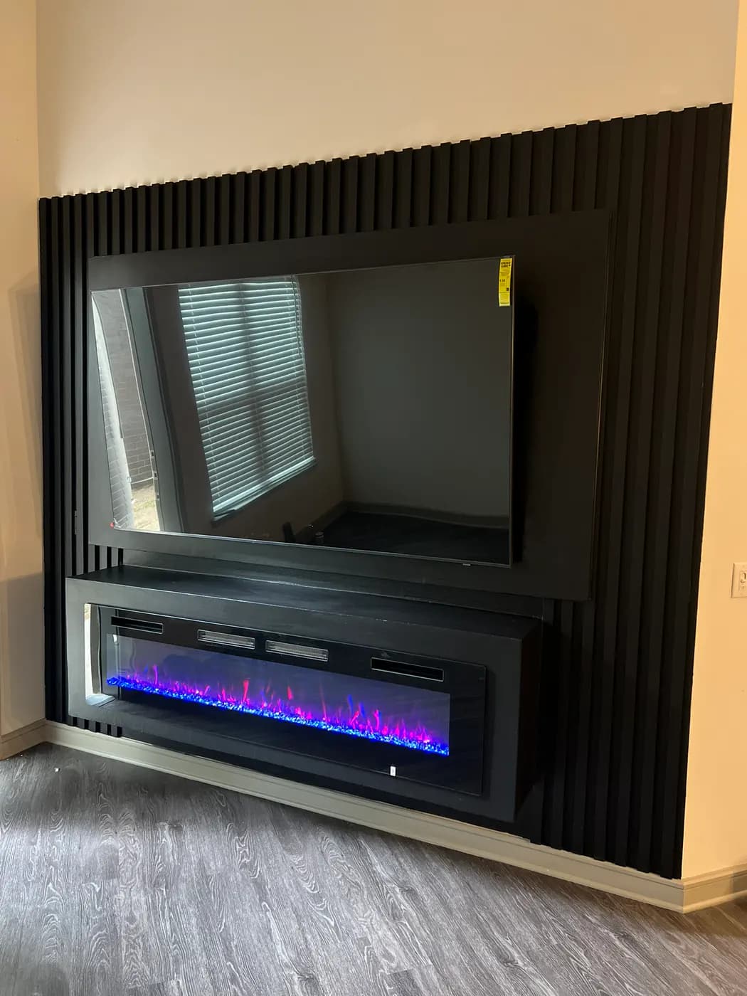 Black fluted media wall with an integrated fireplace
