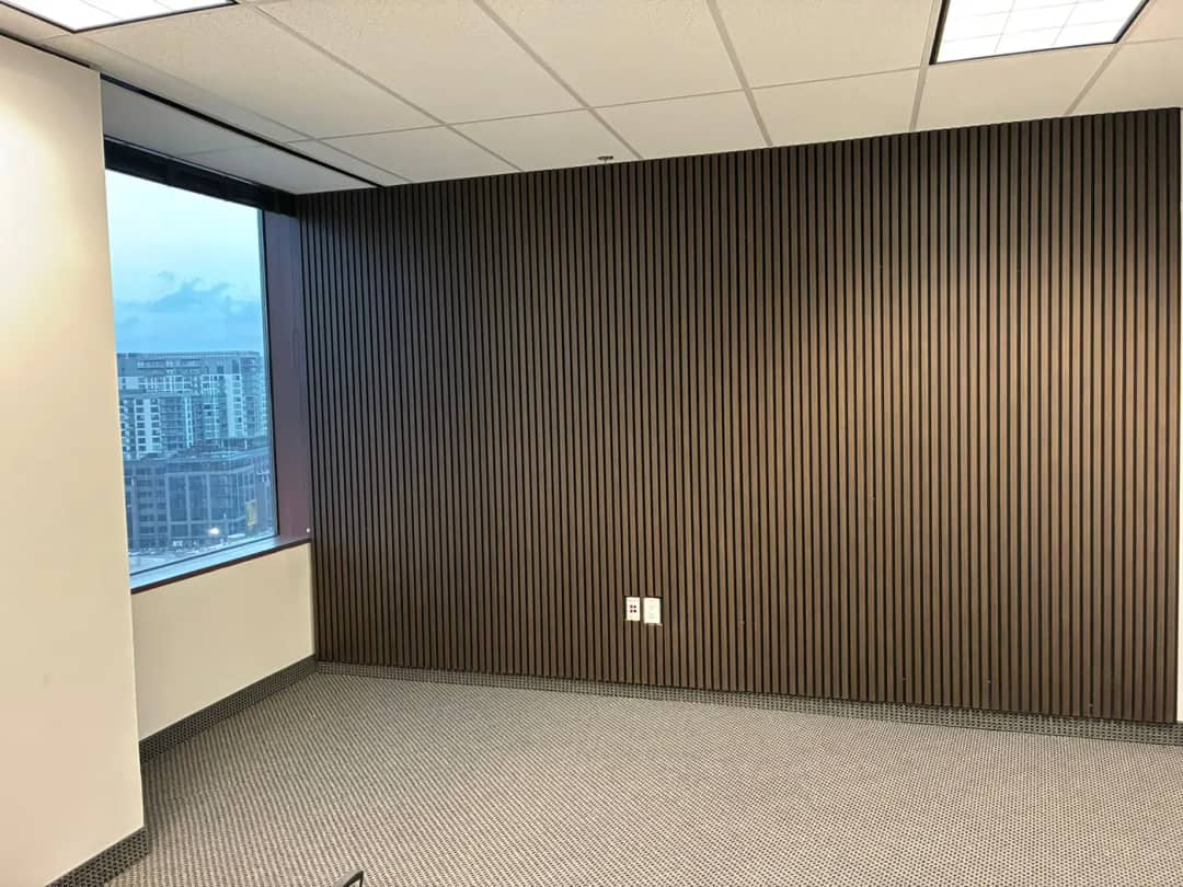 Full-height dark vertical slat wall wrapping a corner interior