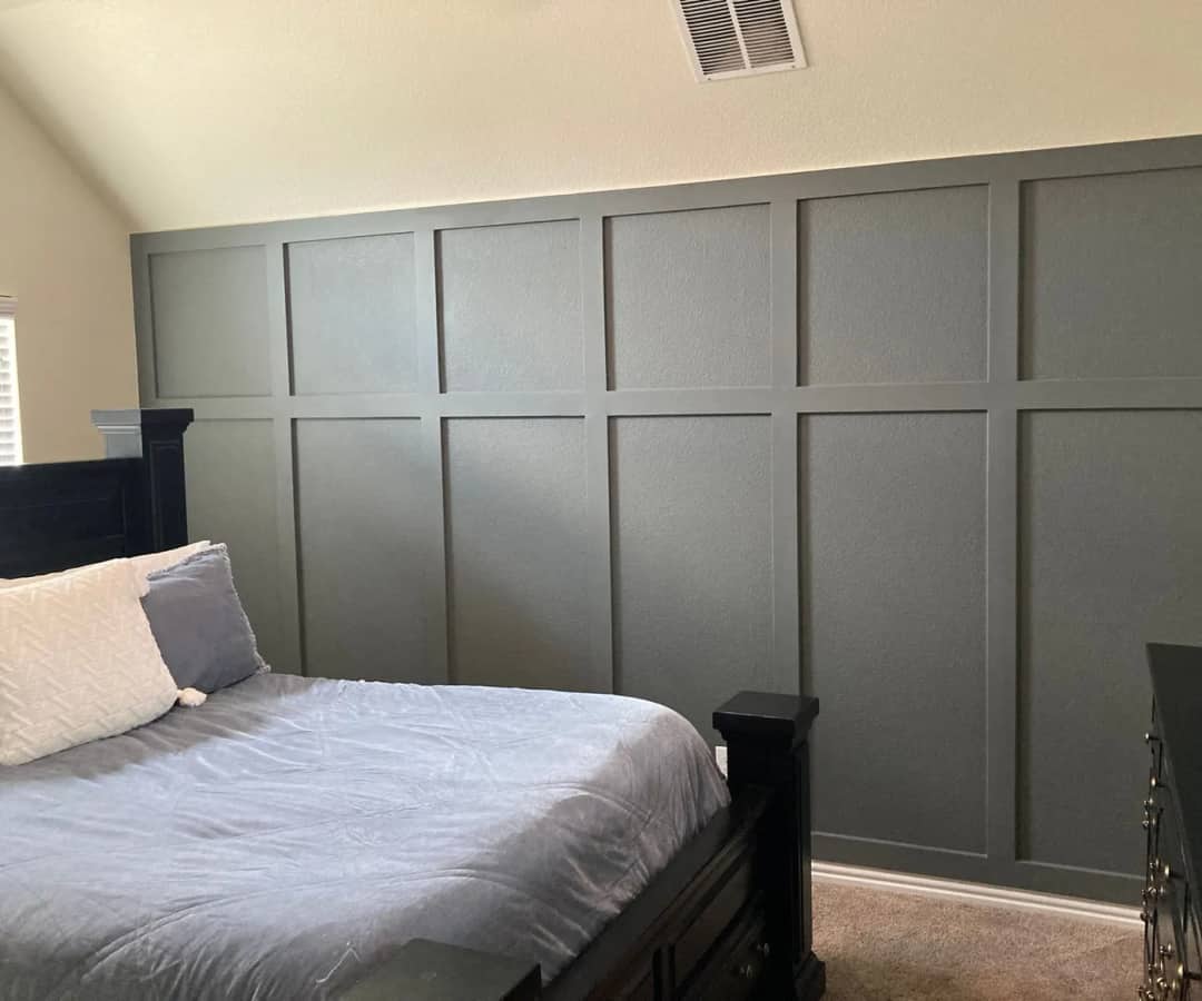 Full-height sage board-and-batten grid wall running the length of a bedroom